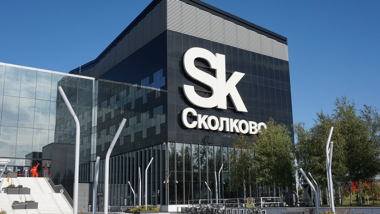 Технопарк инновационного центра «Сколково»: тёмный остеклённый объём с логотипом Sk на фасаде